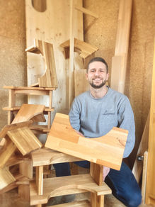 Fabricant de tabourets de toilettes en bois avec plusieurs tabourets autour de lui