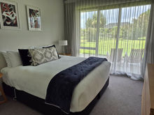 Bedroom with King size bed, chest of drawers, NZ wool carpet, 2 bedside tables & lamps. This one also has a wall mounted Smart TV.