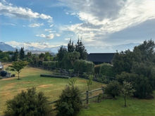 A view from the outdoor deck. Large yards, fully fenced section. In the distance are mountains.