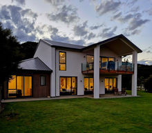 Exterior view away from the street, show the ground floor bedrooms that all open onto the lawn area. The upstairs deck has morning sun.