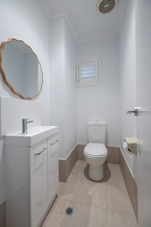 Stylish powder room renovation in Mount Claremont with chrome tapware, timber-framed mirror, and sleek vanity – Elite Makeovers Perth luxury bathroom and powder room specialists.