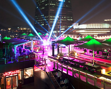 Rooftop bar with a view of Taipei 101 at night, with parasols, pink neon and laser lights.
