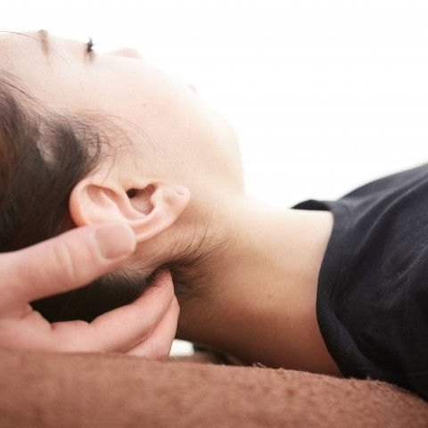 Close-up view of a therapist performing osteopathic treatment on a patient's back