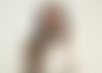 Woman in white shirt smiles against a plain white background. Her long hair is down. The image conveys a cheerful mood.