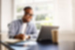 Young African American man excels in online education, studying with laptop and headphones