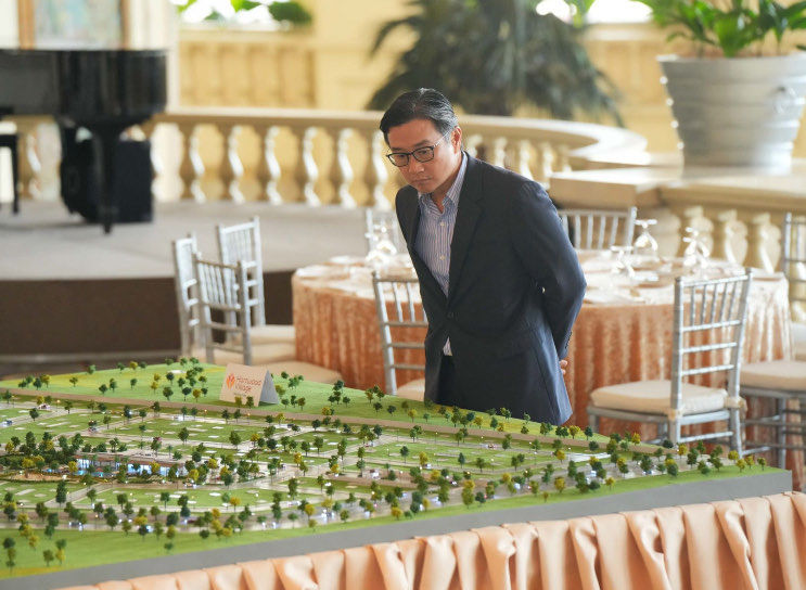 Federal Land chairman Alfred Ty inspects the miniature model of the township project Meadowcrest.