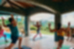 People doing yoga under the pool cabana