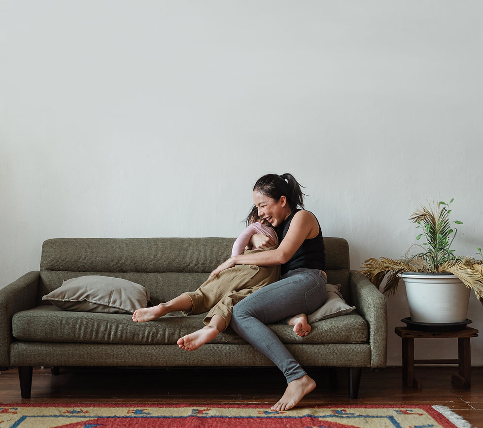Woman cuddling child on couch.