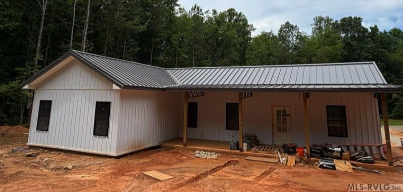 True Metal Supply Post Frame Barndominium with White Board & Batten Steel Siding and Standing Seam Roof.