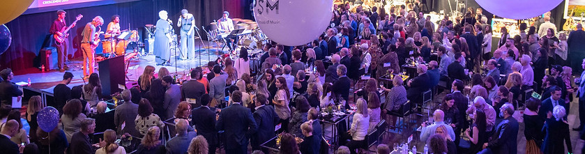 A vibrant event with colorful balloons and a large crowd of people gathered together in celebration.