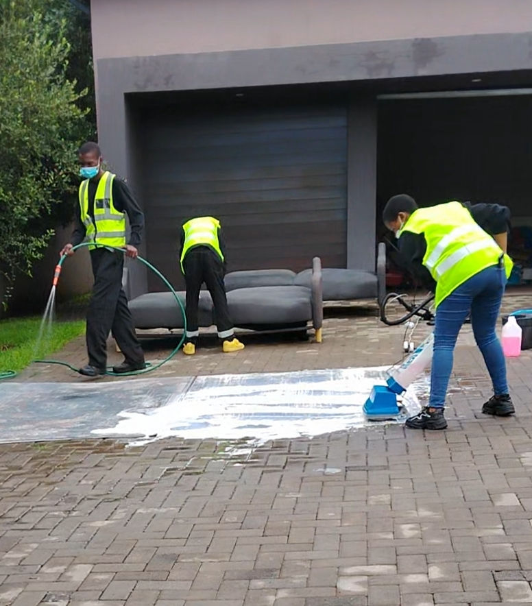 Shanela cleaning services team cleaning a driveway and outdoor furniture.