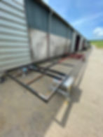 Beginning stages of a shepherd’s hut construction with metal framework outside Tiny Homes workshop