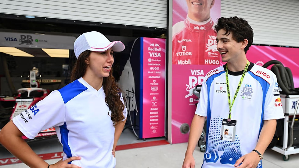 Actor Timothee Chalamet, in a Racing Bulls shirt, chats with Racing Bulls' F1 ACADEMY driver Rafaela Ferreira.