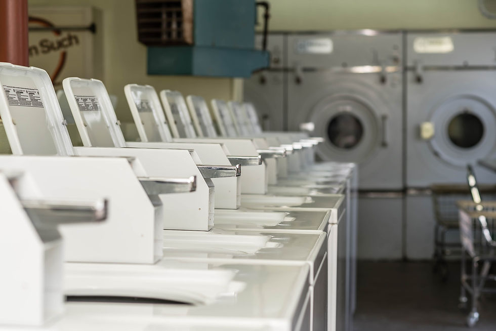 A row of washing machines and dryers from a laundromat