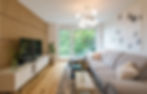 Interior Design eines Wohnzimmers in warmen Tönen mit Holzpaneel an der TV Wand