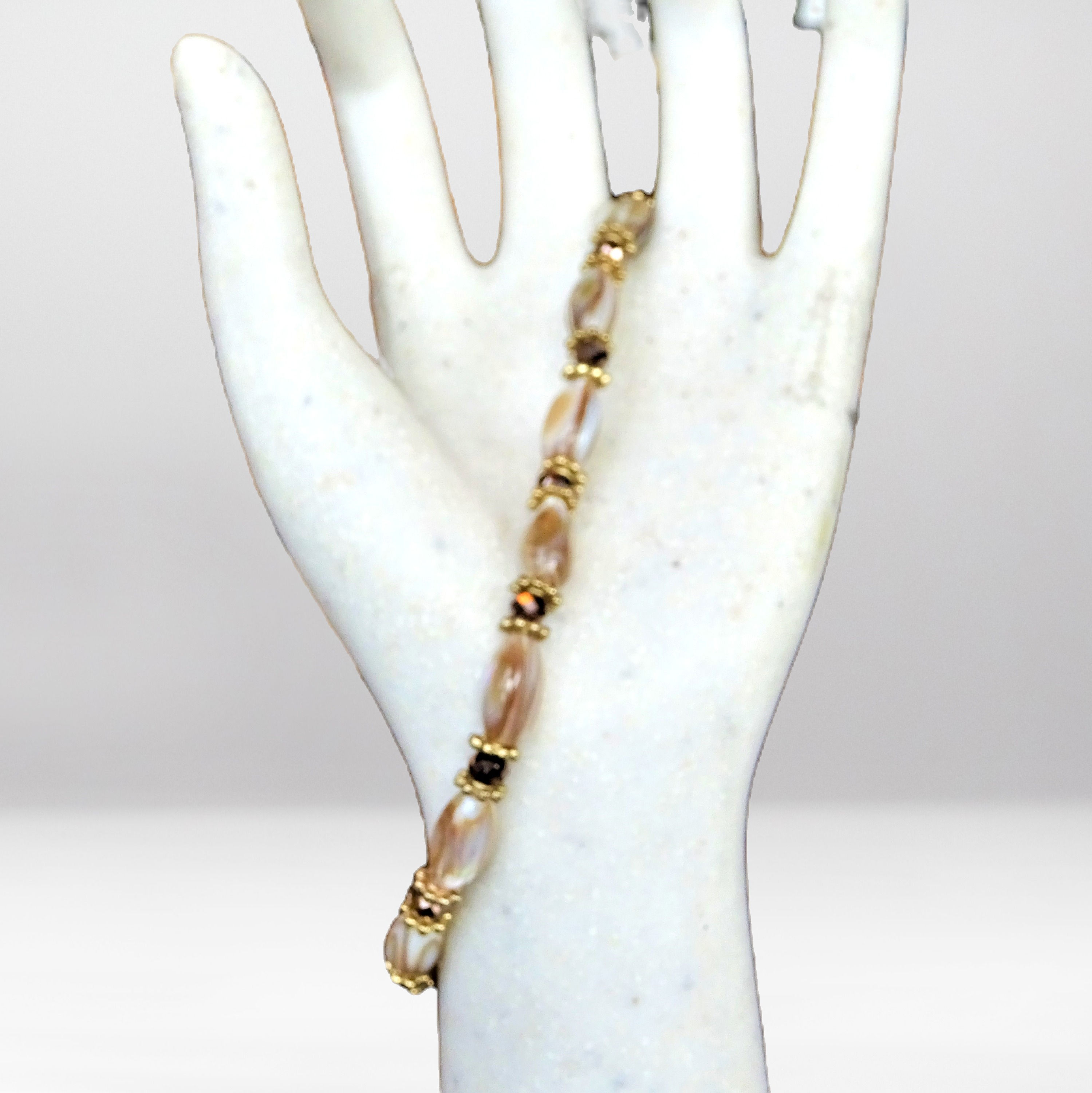 Beaded single row elongated pearl-like ivory and gold bracelet