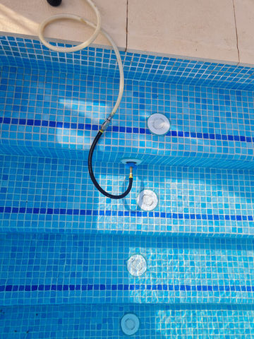 
Las pruebas de presión son una técnica comúnmente utilizada en la detección de fugas en sistemas de tuberías, incluyendo aquellos asociados con piscinas. La idea básica detrás de una prueba de presión es aumentar la presión en el sistema y luego monitorear si hay alguna disminución en esa presión, lo que podría indicar la presencia de una fuga. Aquí hay un resumen del proceso de prueba de presión en el contexto de una piscina:

Preparación del Sistema:

Antes de realizar la prueba de presión, es importante asegurarse de que el sistema esté en condiciones adecuadas y cerrar todas las válvulas y accesorios para aislar la sección de tuberías que se va a probar.
Conexión de la Bomba o Fuente de Presión:

Se conecta una bomba o una fuente de presión al sistema para aumentar la presión interna. En algunos casos, se utiliza aire comprimido o agua.
Aumento de la Presión:

La presión en el sistema se aumenta gradualmente hasta alcanzar un nivel específico. Este nivel de presión se mantiene constante durante un período de tiempo para permitir que se estabilice.
Monitoreo de la Presión:

Durante el período de estabilización, se monitorea la presión en el sistema. Los medidores de presión se utilizan para registrar cualquier disminución en la presión.
Búsqueda de Pérdidas de Presión:

Si hay una fuga en el sistema, la presión disminuirá. Los operadores pueden utilizar instrumentos de medición, como manómetros, para identificar la ubicación aproximada de la fuga en función de dónde se detecte la disminución de la presión.
Reparación de la Fuga:

Una vez identificada la ubicación de la fuga, se pueden tomar medidas para repararla. Esto podría implicar la sustitución de una sección de tubería, la reparación de una conexión o la solución de otro problema que esté causando la fuga.
Las pruebas de presión son una herramienta valiosa para la detección de fugas en piscinas y otros sistemas de tuberías. Es importante realizar estas pruebas de manera segura y siguiendo los procedimientos apropiados. Además, algunas pruebas de presión pueden requerir la intervención de profesionales con experiencia en plomería y sistemas de piscinas.