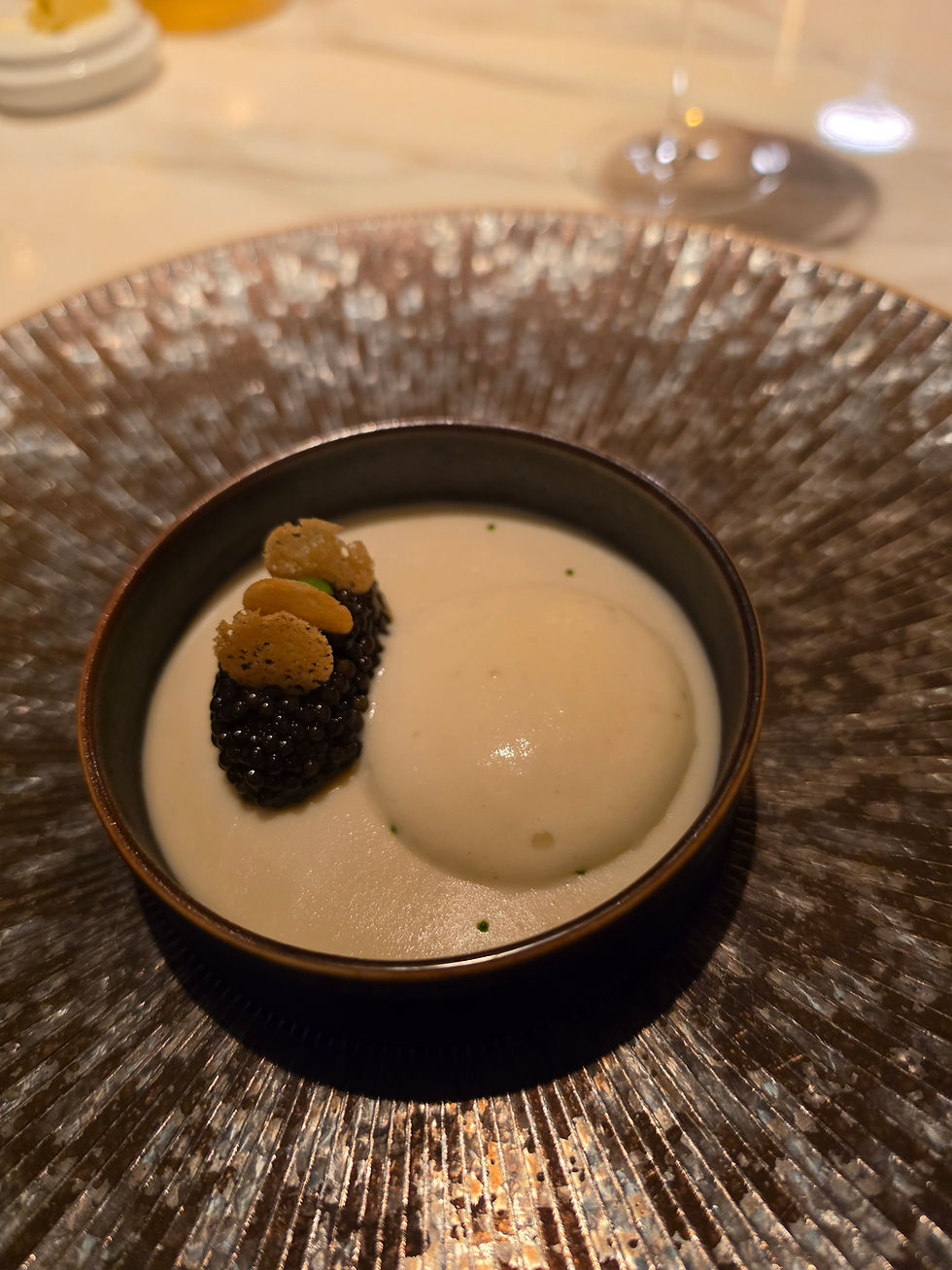 Enchantée caviar course served in a textured dark bowl with a creamy base and caviar garnish with small accompaniments, Disney Wish