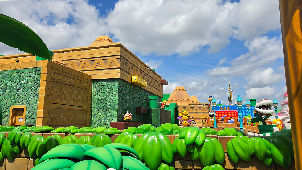 View of Nintendo World at Epic Universe from Yoshi's Adventure ride showing Bowser's Castle and Piranha Plants under blue skies