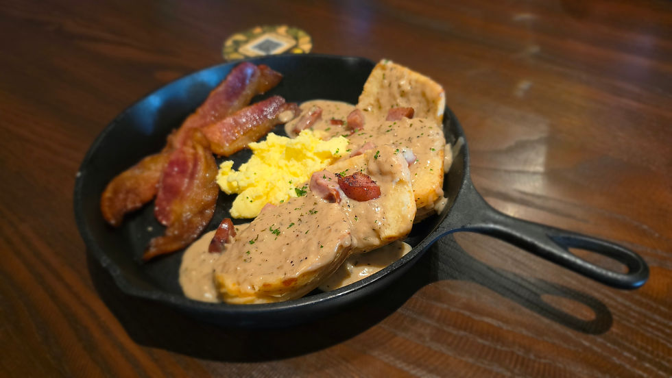 Cast iron skillet breakfast with biscuits and gravy, scrambled eggs and bacon from Star Tavern at Epic Universe