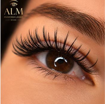 Close-up of long, wispy eyelash extensions with a full, shaped eyebrow.