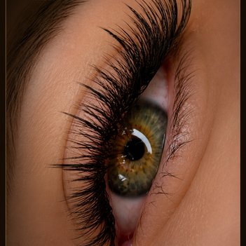 Extreme close-up of an eye with dense, curled eyelash extensions and detailed lash volume.
