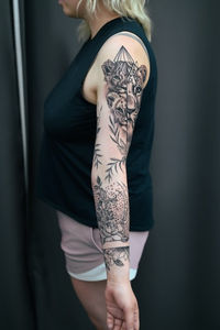 Woman's arm tattoo with lions and plants, FINE LINE TATTOO PICTURES.