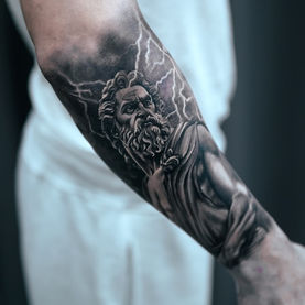 Arm with Zeus tattoo, gray and black, lightning in background, Andre Zechmann.
