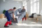Two young workers lift up heavy sofa together. Young men from moving company and lorry del