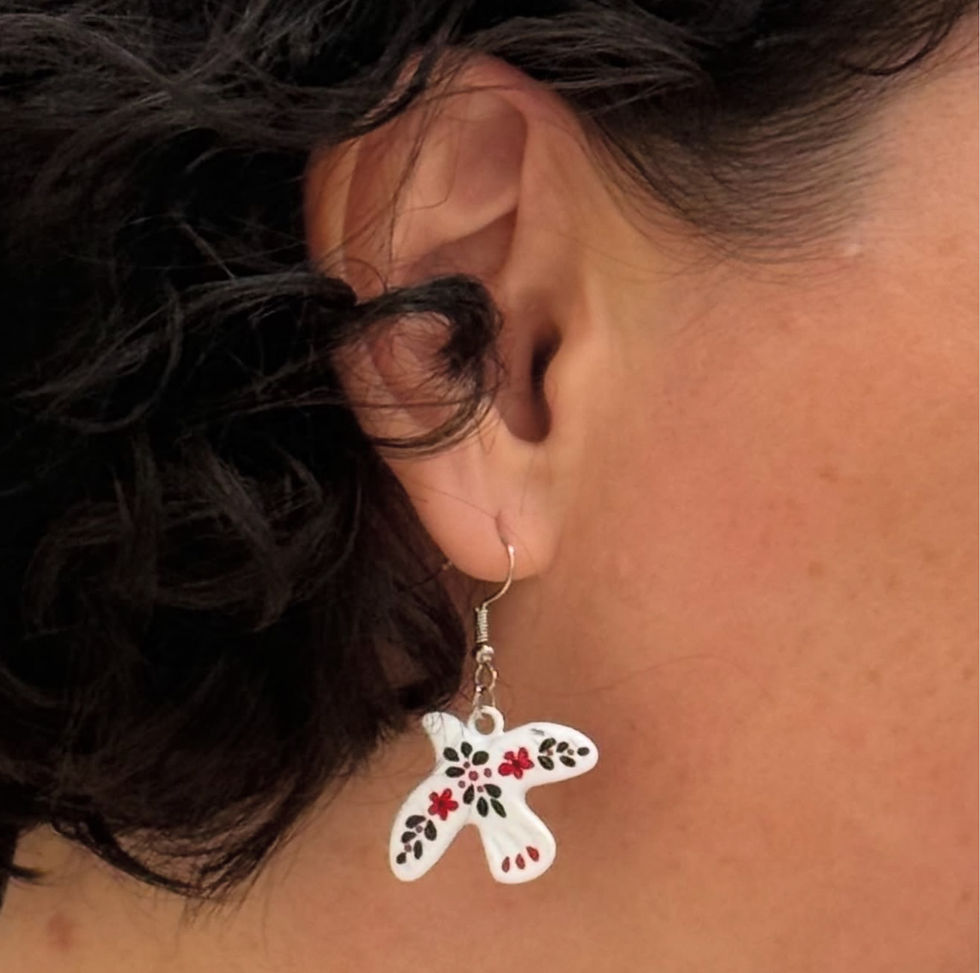a girl wearing an earring with white ceramic dove pendant and hand painted black & red ukrainian embroidery pattern