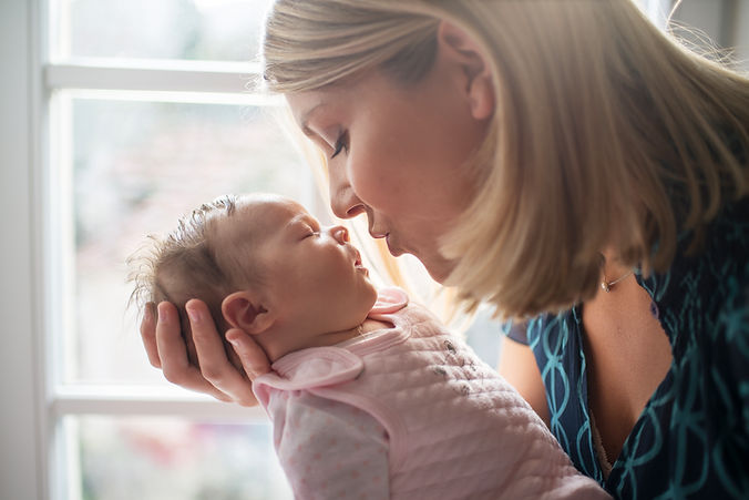 un maman qui va embrasser son bébé