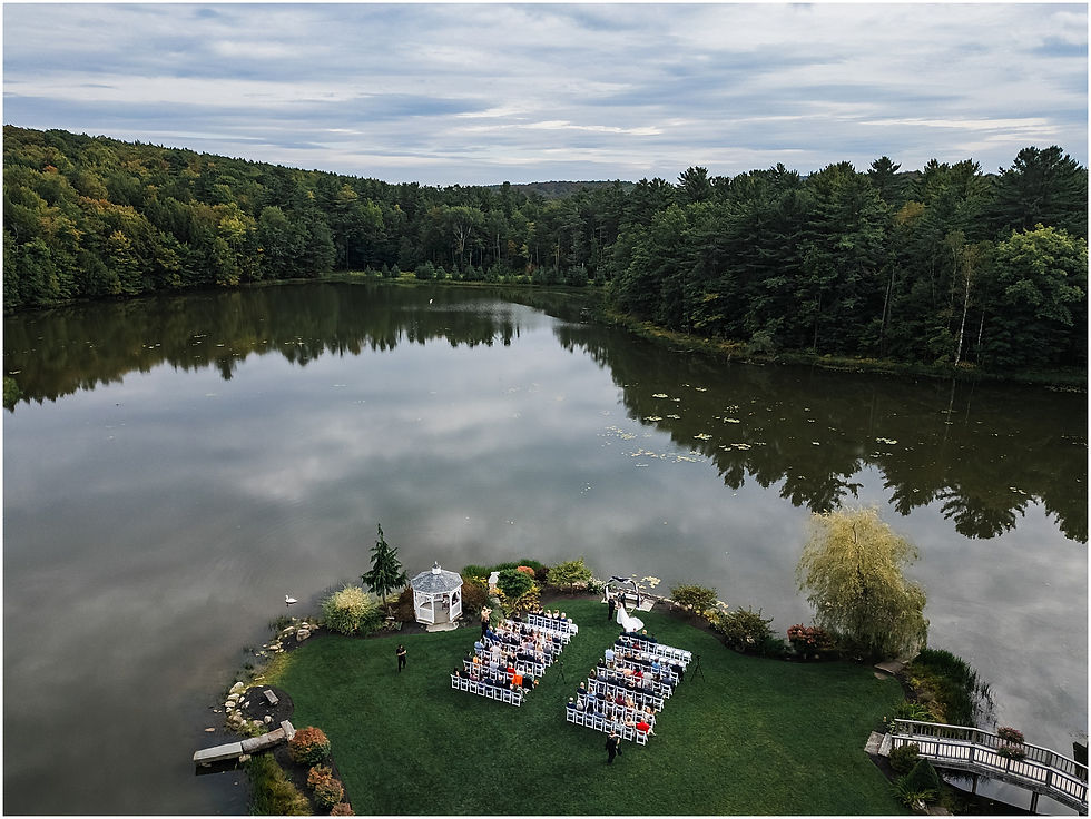 Aerial view of an outdoor wedding ceremony by the water at a private venue in Cooperstown, New York, The Rosemary at Spano Lake