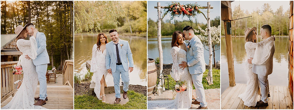 Couple in wedding attire by a lake, embracing and smiling. Bride in lace dress, holding flowers; groom in light blue suit. Woods in background.