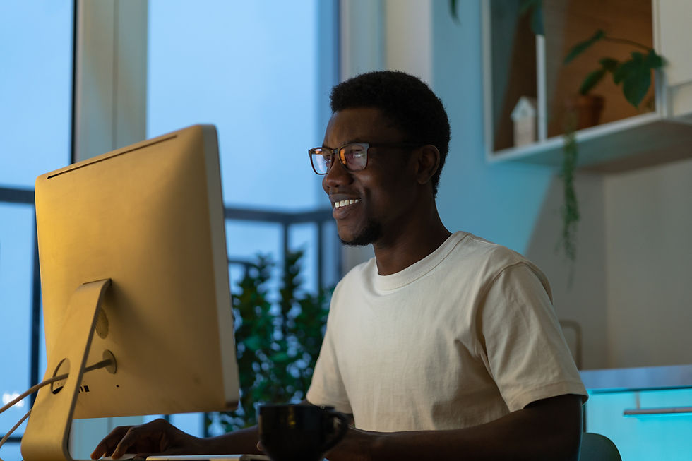 Smiling man using desktop computer at night