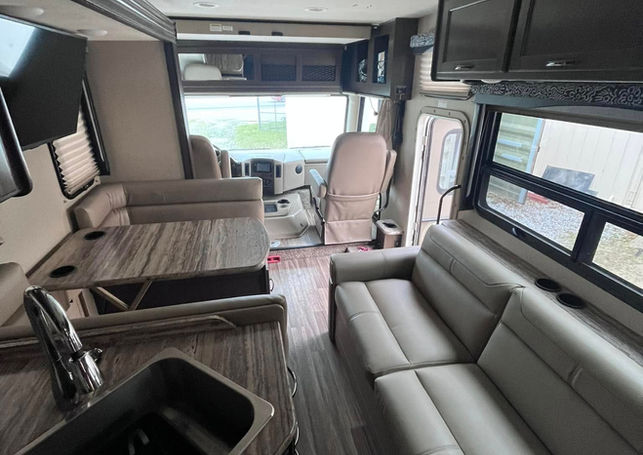 RV dinette and kitchen sink area with gray leather seating