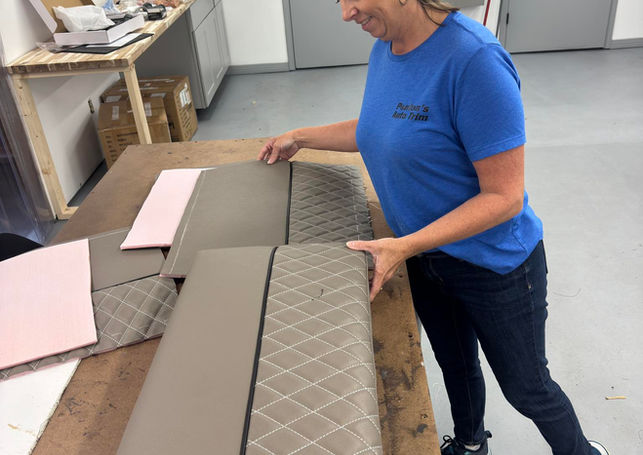 Penton's technician working with tan and gray quilted RV cushion pieces on a workbench