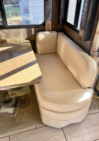 Tan leather RV dinette booth with a marble-look table