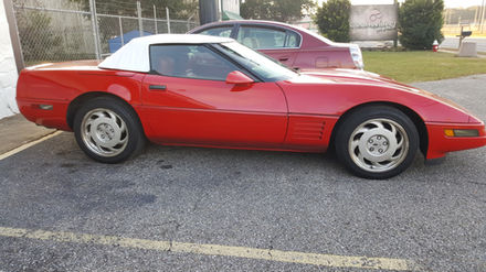 Red Corvette with white convertible top