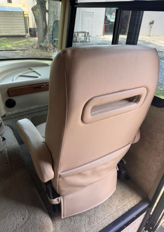 A close-up of a tan leather RV captain's chair back.