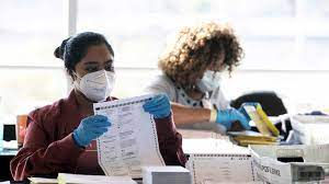 Election workers looking at ballots