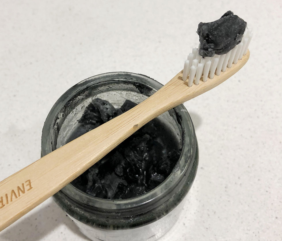 DIY chargoal toothpaste in glass jar with bamboo toothbrush