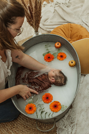 Auxiliaire de puéricultrice donnant le bain à un bébé pour sa séance bain de lait enveloppé 33