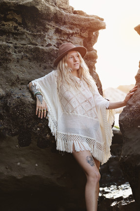 Portrait assis dans une faille rocheuse à Anglet, chapeau et châle en crochet blanc