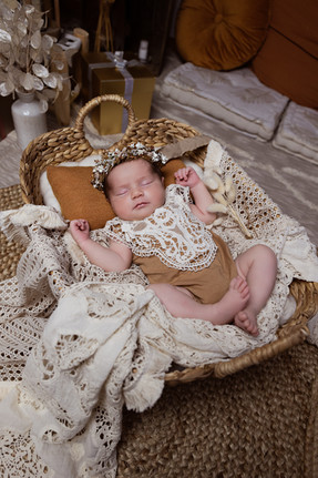 Nouveau-né allongé dans un panier en osier dans une tenue bohème