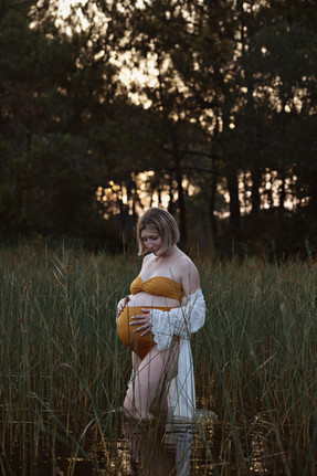 femme enceinte dans un lac au coucher du soleil