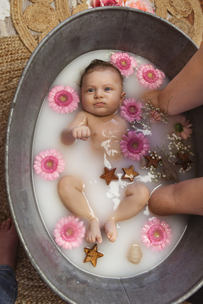 grand bébé dans un bain de lait fleuri et enveloppé