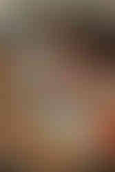 Bébé dans un bain de lait avec des fleurs oranges et du feuillage dans le bain