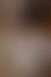 bébé dans un contenant en bois habillée d'une robe bohème et entourée de tissus en dentelle