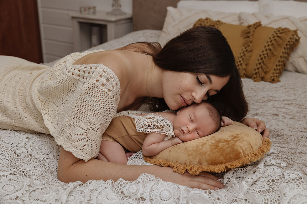 Maman allongé sur un lit avec une jolie robe bohème et son bébé elle aussi sur le ventre.