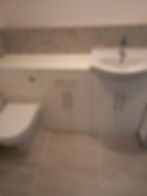 Modern bathroom with white vanity, sink, and toilet